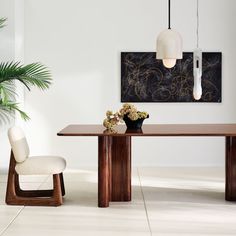 a dining room table with two chairs next to it and a plant in the middle