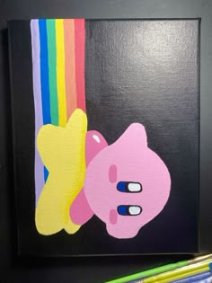 a painting of a pig with a rainbow painted on it's face next to some colored pencils