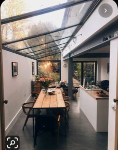 a dining room table and chairs under a glass roof