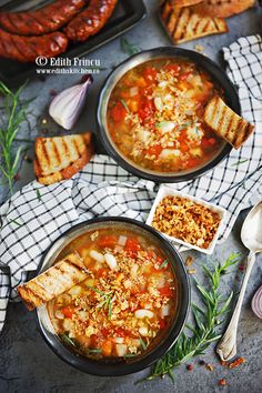 two pans filled with soup next to grilled bread