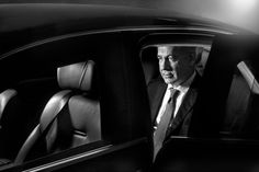 a man in a suit and tie sitting in a car