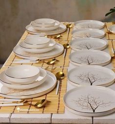 the table is set with white plates and gold place settings for dinner guests to enjoy