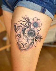 a woman's thigh with a lion and flowers on it