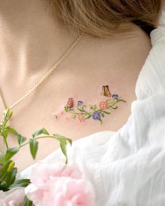 a woman's chest with flowers and butterflies on it