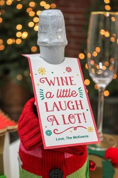 a wine bottle with a sign attached to it that says wine is little laugh at a lot