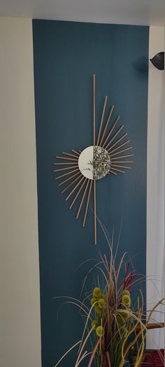 a clock on the wall next to a potted plant