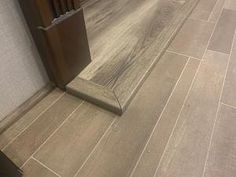 a bathroom with wood flooring and tile on the walls, along with a toilet