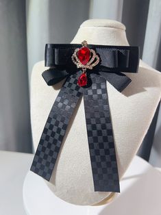 Add a touch of regal charm to your outfit with our rhinestoned crown bow tie/brooch. Available in both black and red, this versatile accessory features a dazzling rhinestone-encrusted crown design that exudes elegance and sophistication. Wear it as a bow tie or use it as a brooch to elevate your look with a hint of royal allure. Perfect for adding a touch of glamour to any outfit, this one-of-a-kind piece is sure to turn heads and make a statement. Whether you're dressing up for a special occasi Black Bow Tie Jewelry For Party, Black Bow Tie Jewelry For Formal Occasions, Black Jewelry With Decorative Bow For Party, Formal Red Rhinestone Brooch, Formal Red Rhinestones Brooches, Black Brooch With Decorative Bow For Evening, Formal Black Brooch With Decorative Bow, Elegant Red Pins For Party, Elegant Red Party Pins