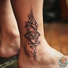 a woman's foot with a tattoo design on the side of her leg and an intricate