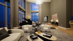 a living room filled with lots of furniture and a grand piano in the middle of it