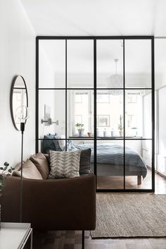 a living room filled with furniture and a large glass door that leads to a bedroom