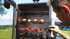 a man is looking at some food on the grill