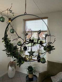 a living room filled with furniture and christmas ornaments hanging from the ceiling over a window