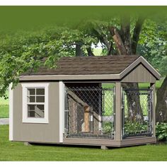 a small dog house in the middle of a yard with a fence around it's perimeter