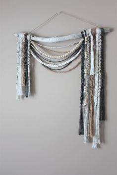 a white wall hanging with beads and tassels