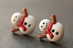 two snowmen wearing red scarves are sitting next to each other on the table