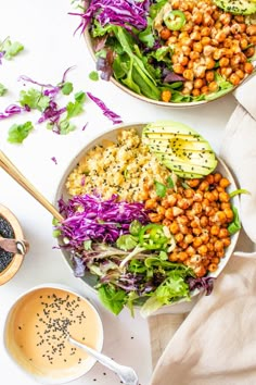 two bowls filled with different types of salads next to some dipping sauce on the side