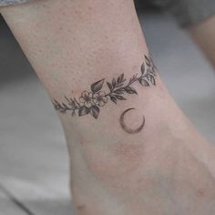 a woman's foot with a flower and crescent tattoo on her left side ankle