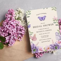 a bouquet of flowers next to an envelope with the word bridal shower on it