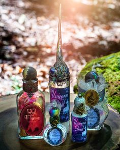 three bottles of perfume sitting on top of a tree stump