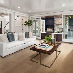 a living room with white furniture and wood floors