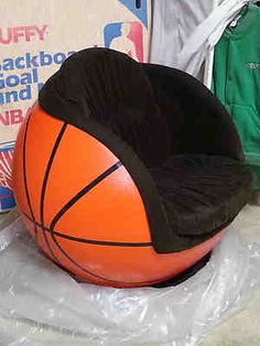 an orange and black basketball sitting on top of a plastic bag in front of a sign