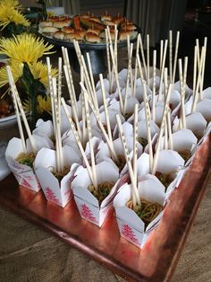 there are many small cups with sticks in them on the tray and one is filled with food