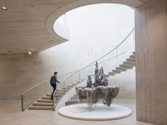 a man is walking up the stairs in front of a sculpture