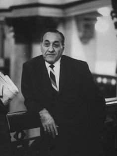 a man in a suit and tie sitting on a bench