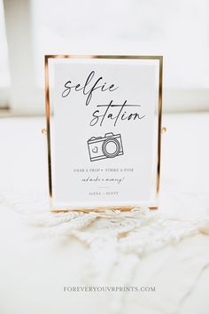 a sign that says selfie station with a camera on it and the words selfie station written in black ink