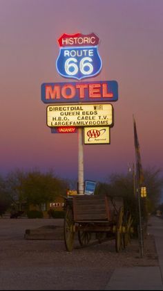 a motel sign with a wagon underneath it