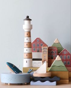 wooden boats and lighthouses sit on a table