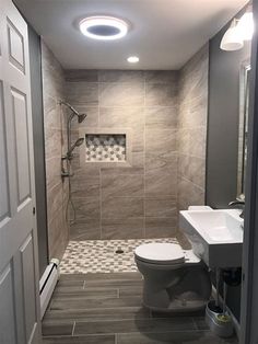 a bathroom with a toilet, sink and shower stall in it's own area