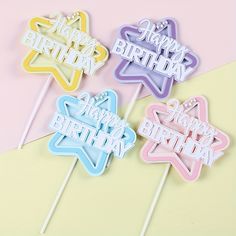 four happy birthday cake toppers on a pink and yellow background