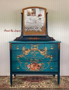 a blue dresser with an ornate mirror on top