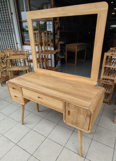 a wooden table with a mirror on it and chairs in front of the window behind it