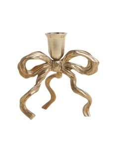 a gold candle holder with a large bow on the front and bottom, sitting on a white background