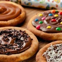 several decorated cookies on a table with chocolate frosting and sprinkles in the middle