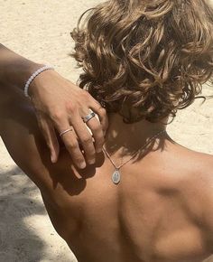 the back of a woman's shoulder with a diamond ring on her left hand