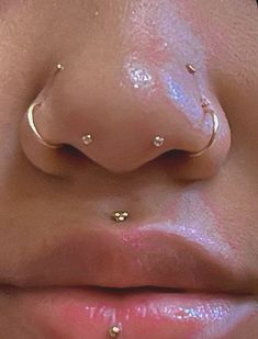 a close up view of a woman's nose with piercings on her nose