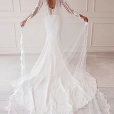 a woman wearing a white wedding dress with long sleeves and a veil on her head