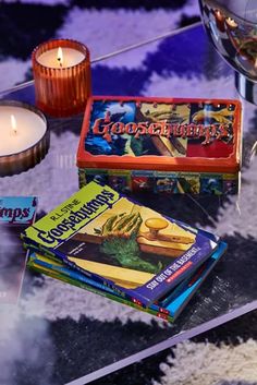 candles and books are on a glass table