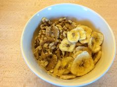 a bowl filled with bananas and nuts on top of a table