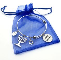 a silver bracelet with two charms and a hanukkah menorah charm