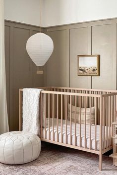 a baby's room with a crib, bed, and lamp in it