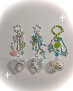 three charms are attached to each other in the shape of heart and star shaped objects