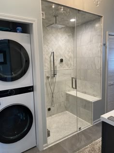 a washer and dryer in a bathroom next to a walk - in shower