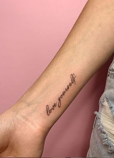 a woman's arm with the word love yourself tattooed on her left inner arm