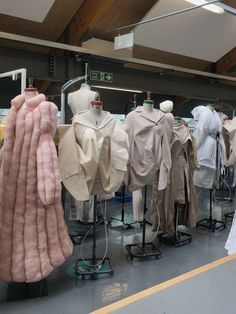 several mannequins are lined up in front of each other with coats on them