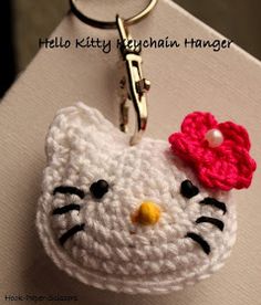 a crocheted hello kitty keychain has a flower on it